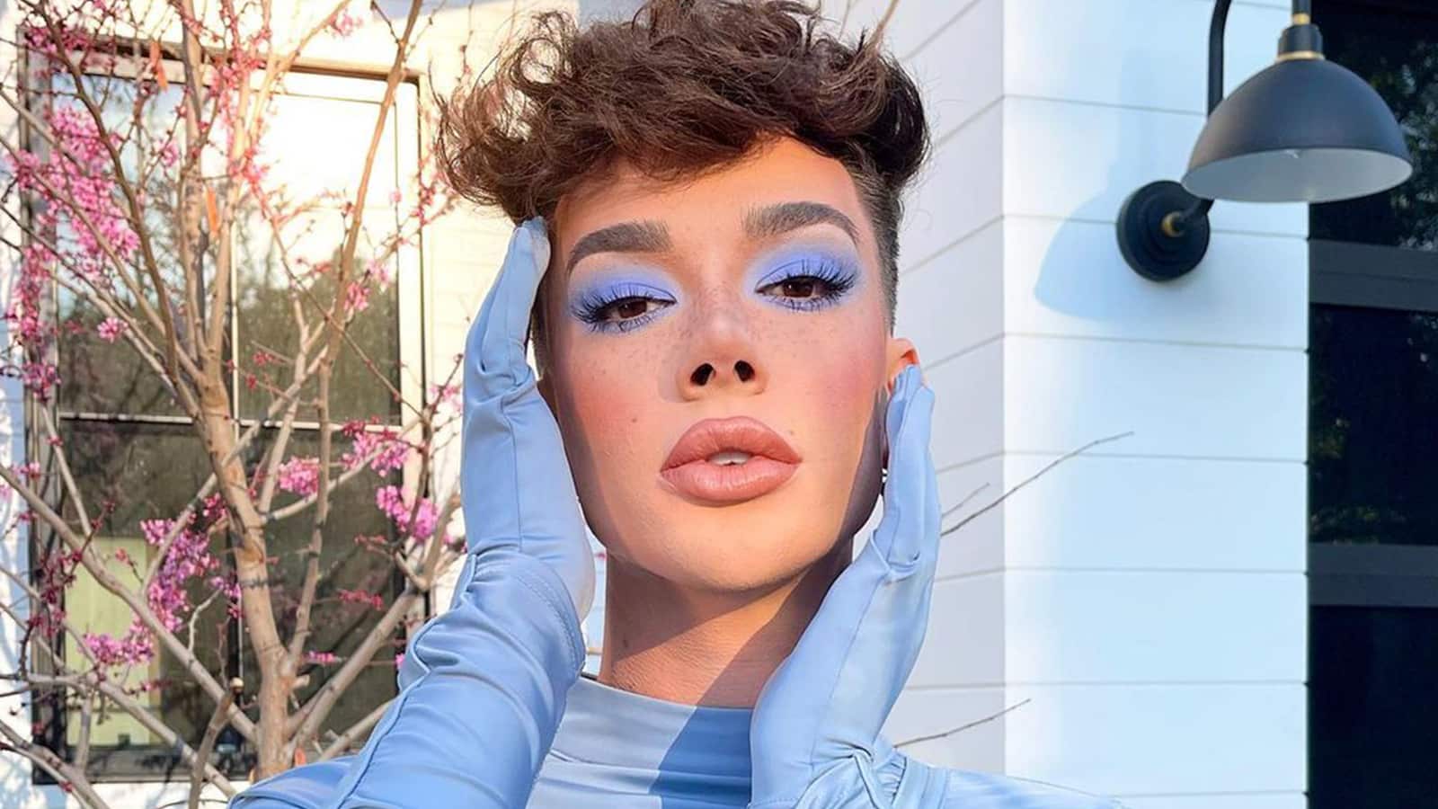 James Charles poses in blue make up