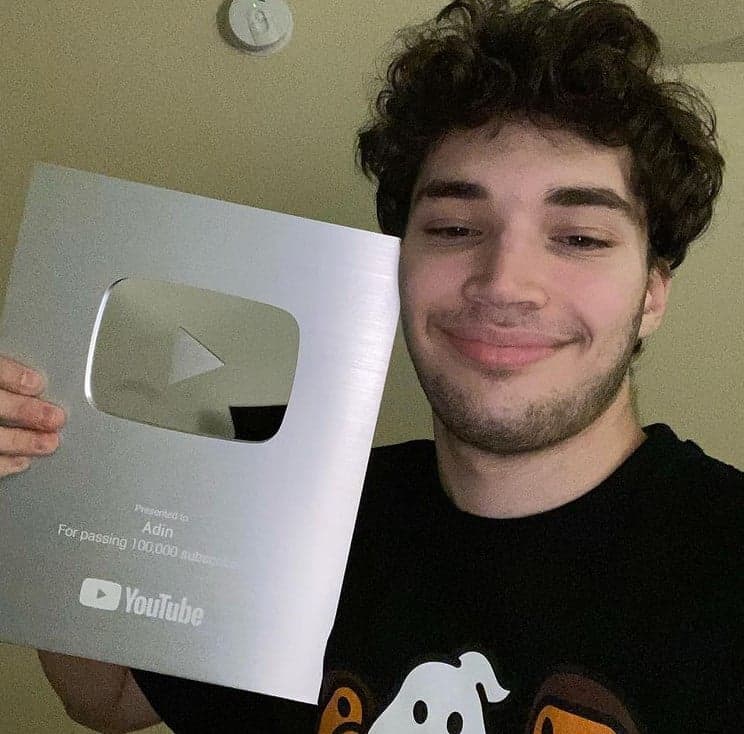 Adin Ross holding up a YouTube silver plaque