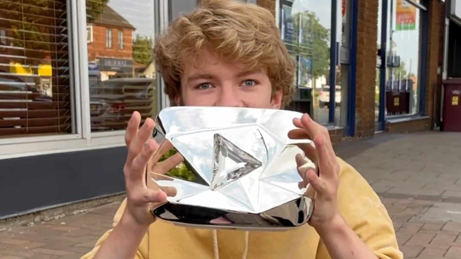 TommyInnit holds his YouTube Play Button