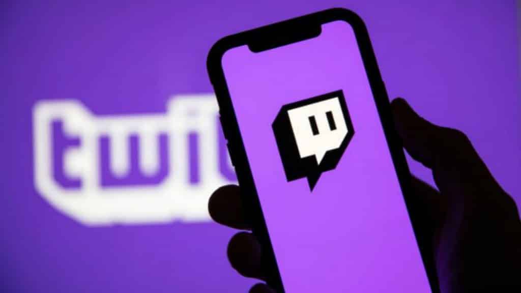 twitch logo on a phone with the text logo behind it on a screen