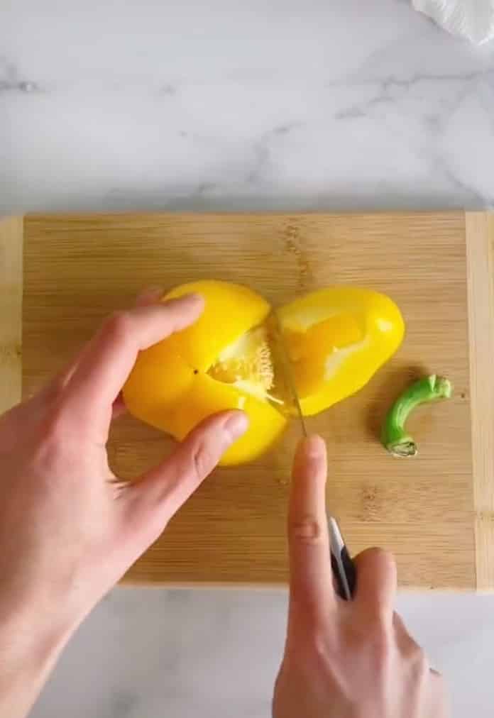 A yellow bell pepper being cut