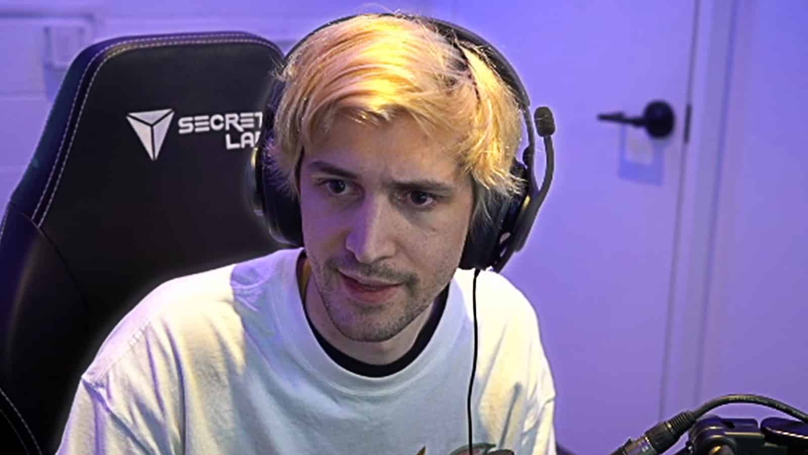 xQc streams on Twitch in purple room.