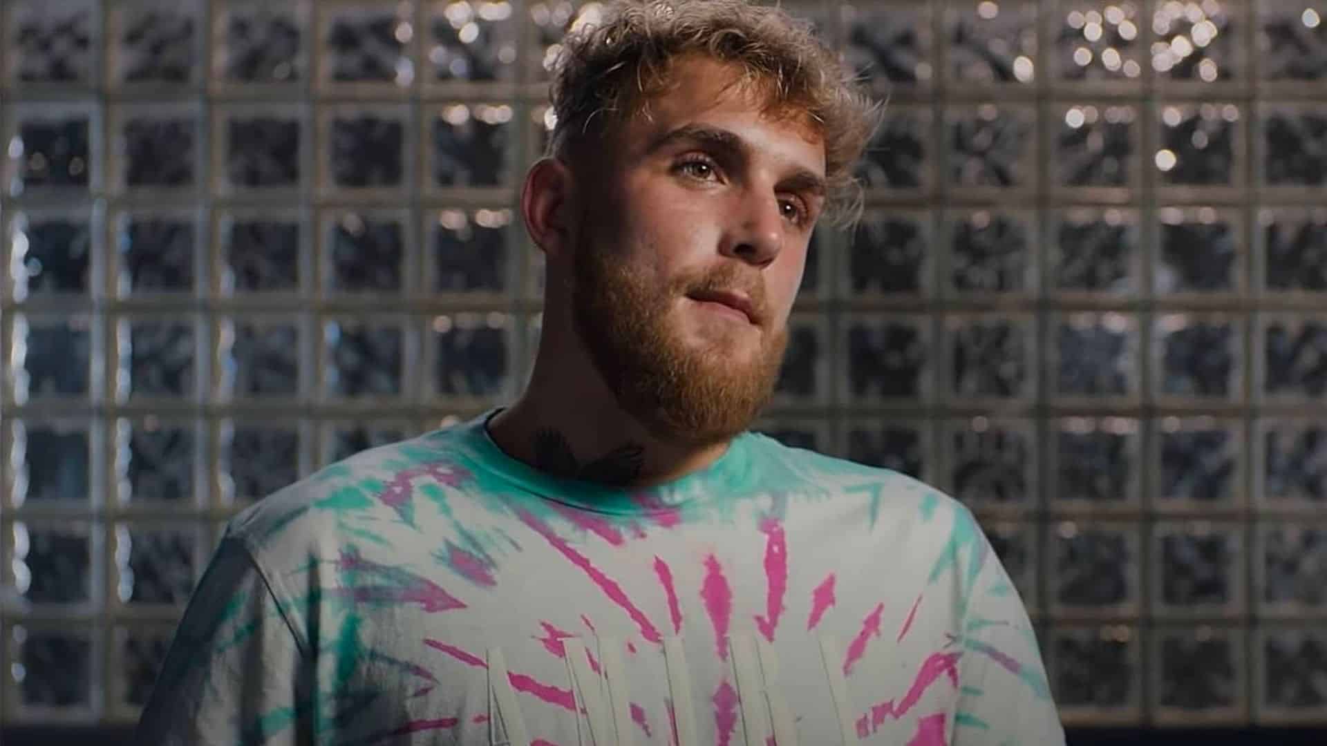Jake Paul talking to camera with glass wall in background