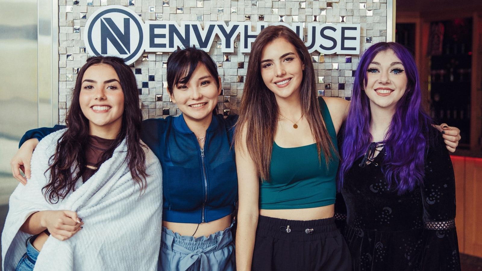 Botez sisters, justaminx and codemiko standing in front of envy house sign