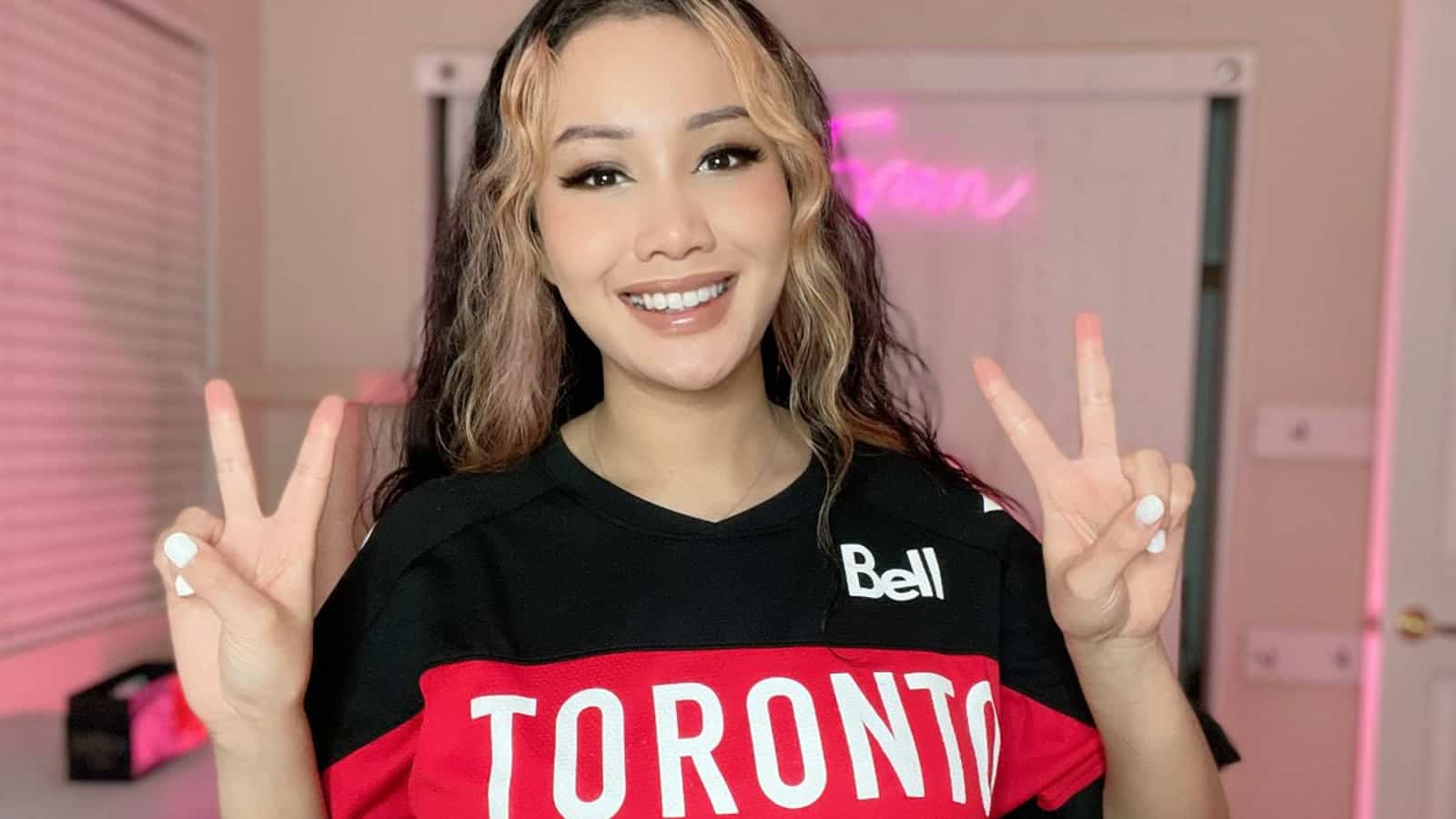 overwatch twitch streamer fran looks at camera doing peace signs in toronto defiant t-shirt