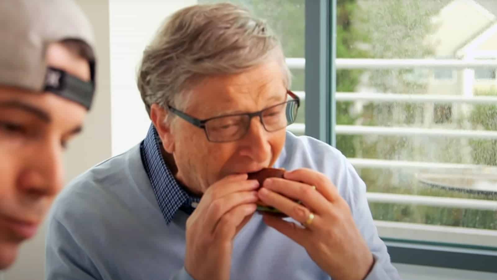 Microsoft co-founder Bill Gates eating vegan burger during Mark Rober YouTube segment screenshot.