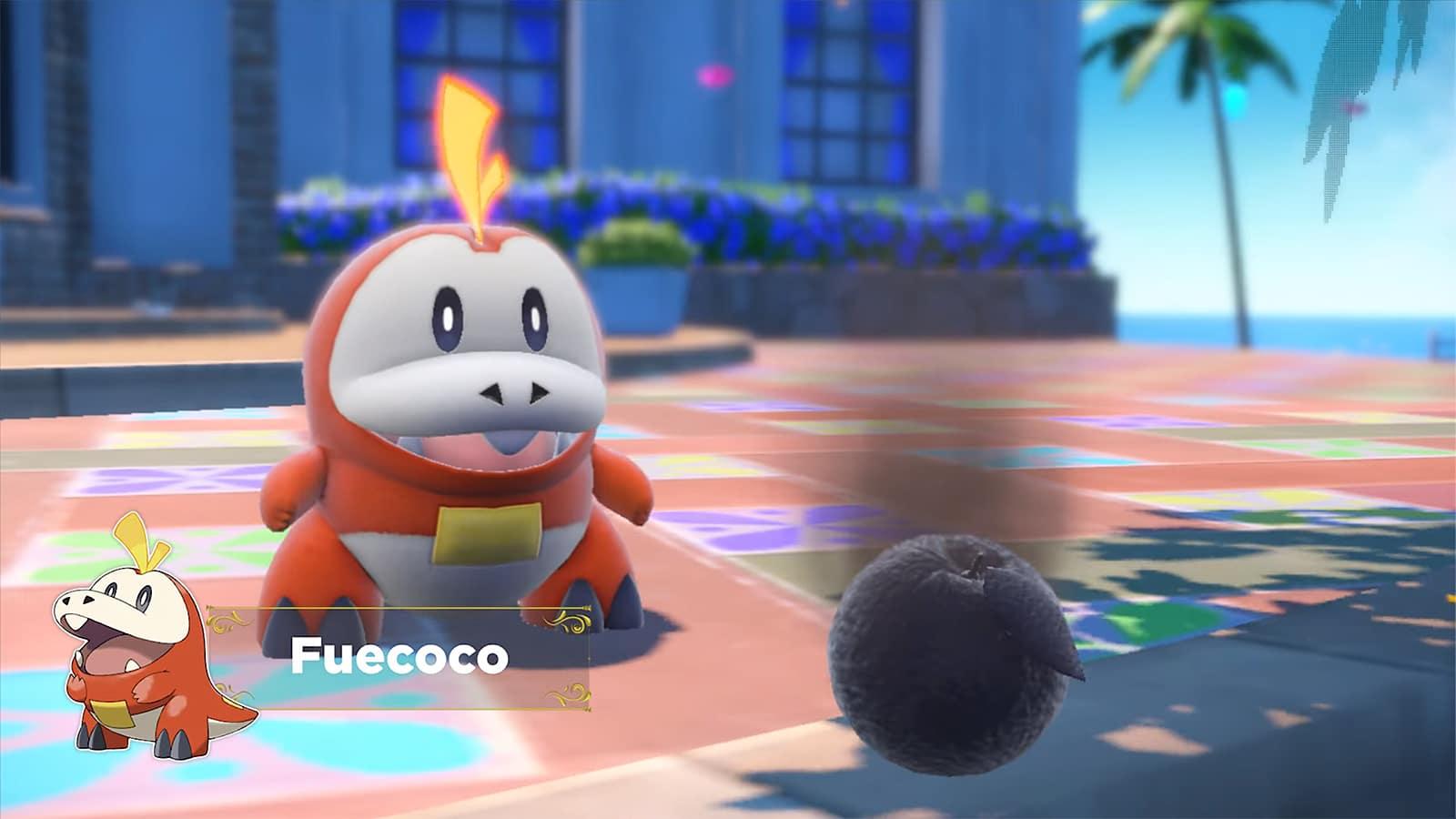 Fuecoco, a fire-type in Pokemon Scarlet and Violet sitting next to a burnt fruit