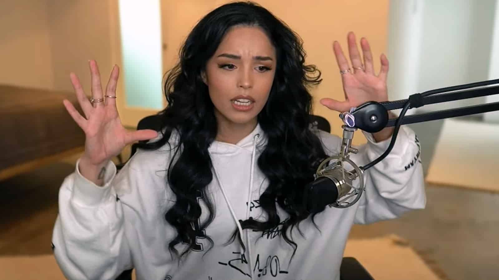 Valkyrae streaming on YouTube with her hands up in the air