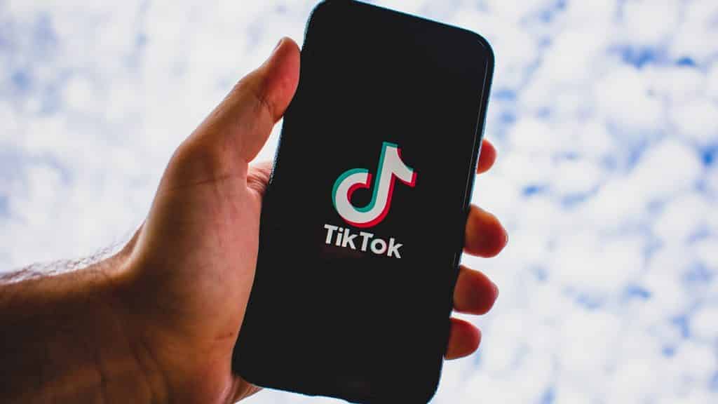 Phone with TikTok logo in front of clouds