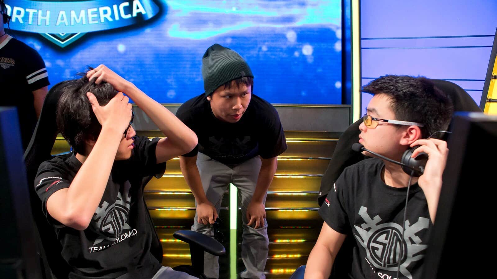 TSM CEO Andy Dinh talks to two players on stage at the LCS