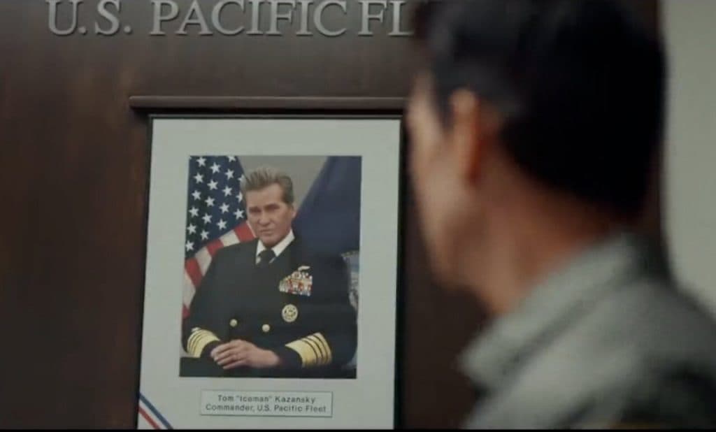 Tom Cruise's Maverick looking at a photo of Val Kilmer's Iceman in Top Gun: Maverick.