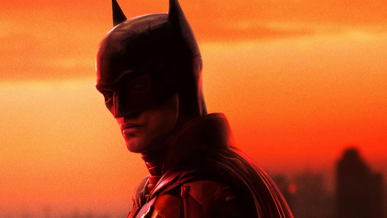Robert Pattinson as the batman against an orange sky