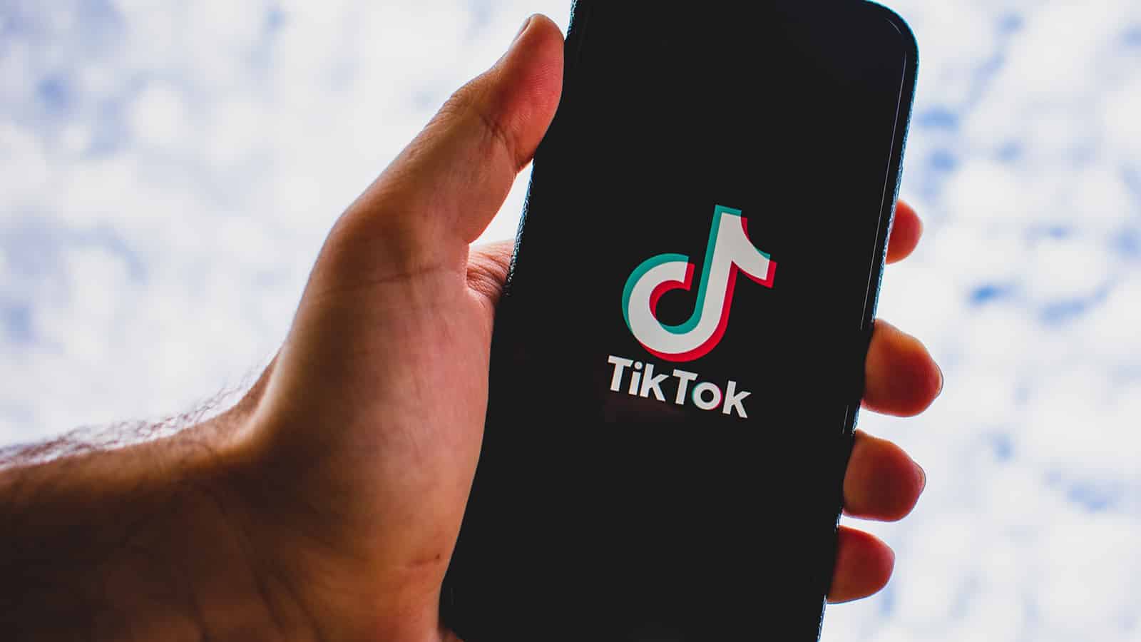 hand holding phone with tiktok logo