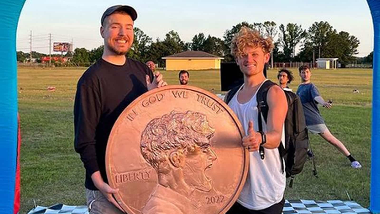 MrBeast and Ryan Trahan holding penny