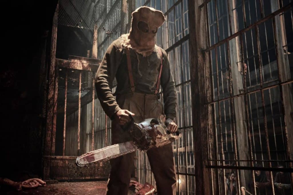 A man holding a chainsaw in the Resident Evil Netflix series.