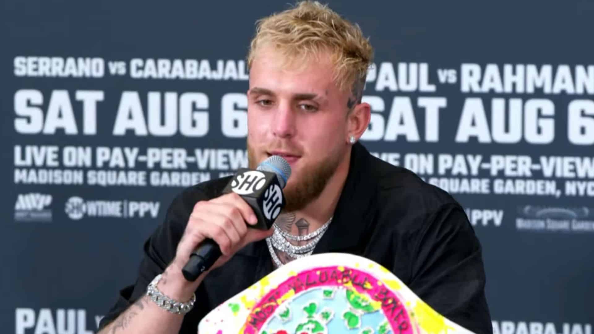 Jake Paul talking at press conference with mic in hand