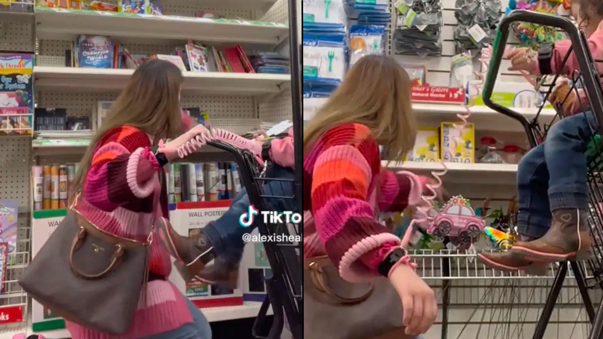 Mom holding onto daughter in shopping cart with pink leash