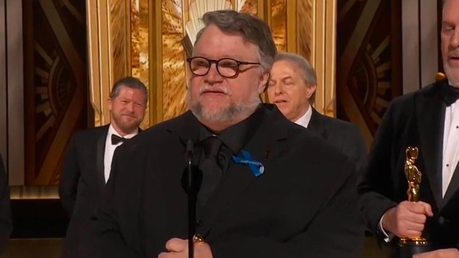 Guillermo del Toro wearing a blue ribbon at the Oscars