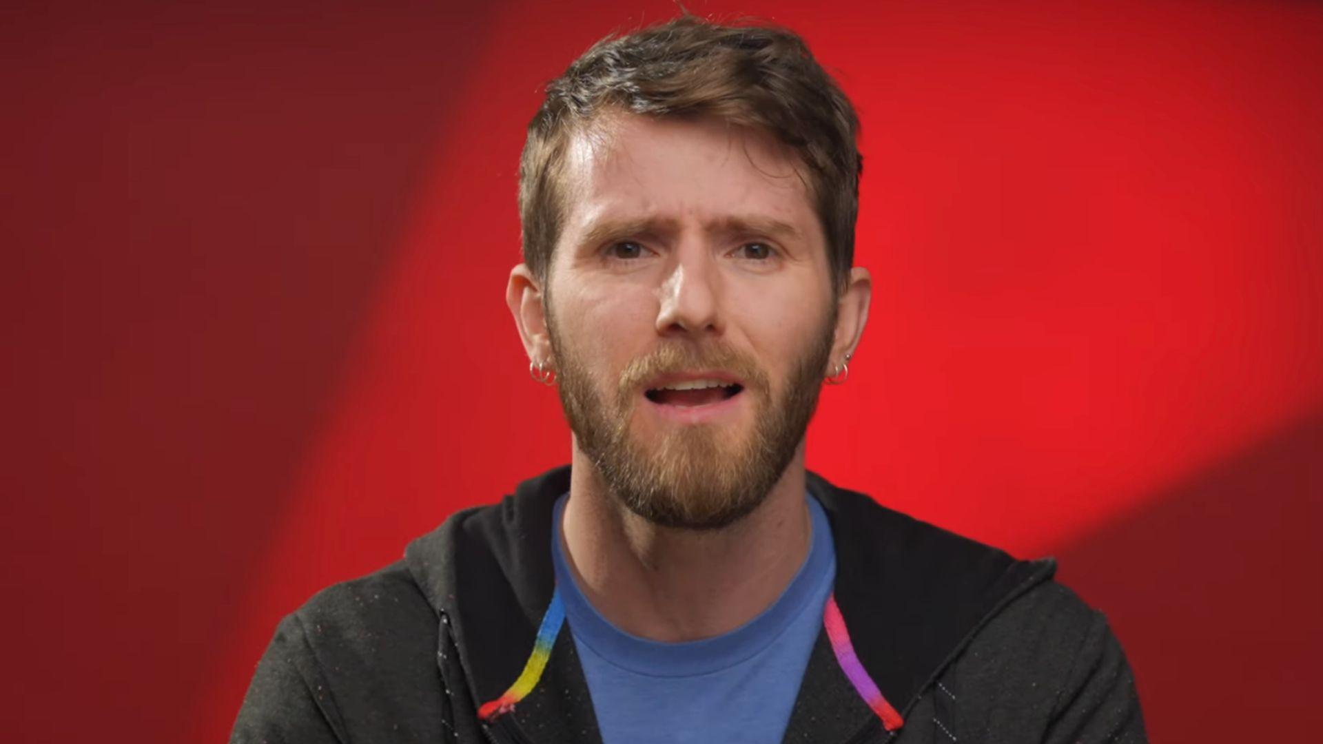 LinusTechTips talking to camera in front of red background