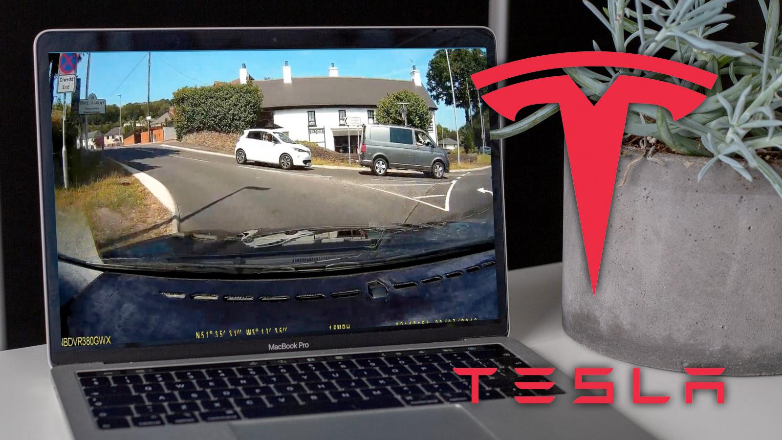 tesla logo above a laptop with dashcam footage on it