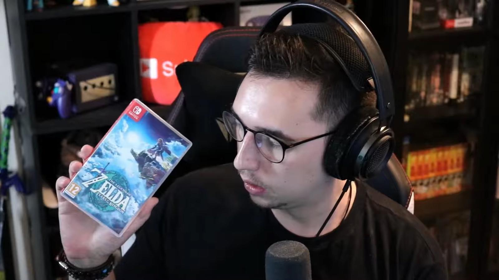 GameStop employee holding Tears of the Kingdom case