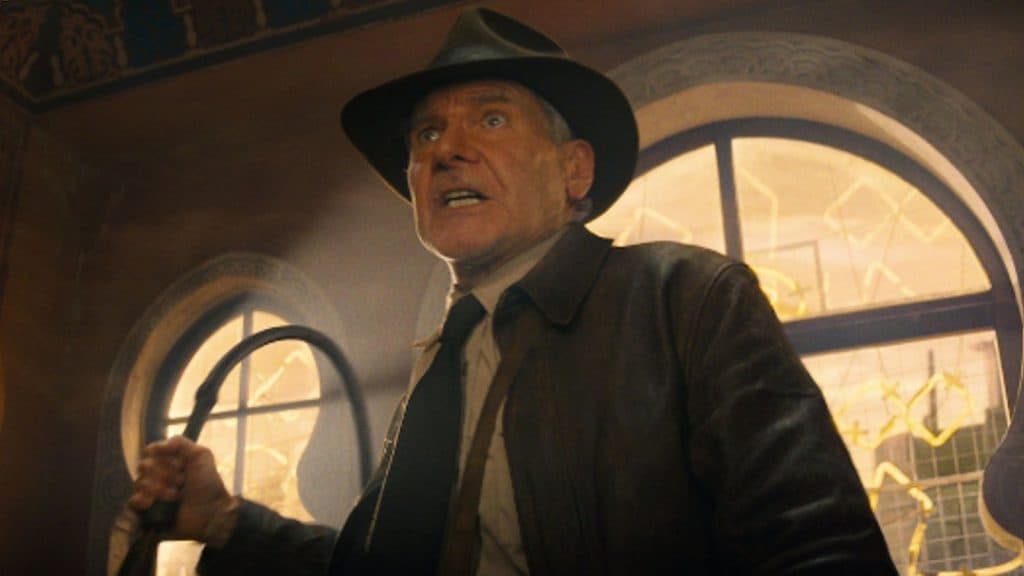 A close up of Harrison Ford as Indiana Jones holding a whip