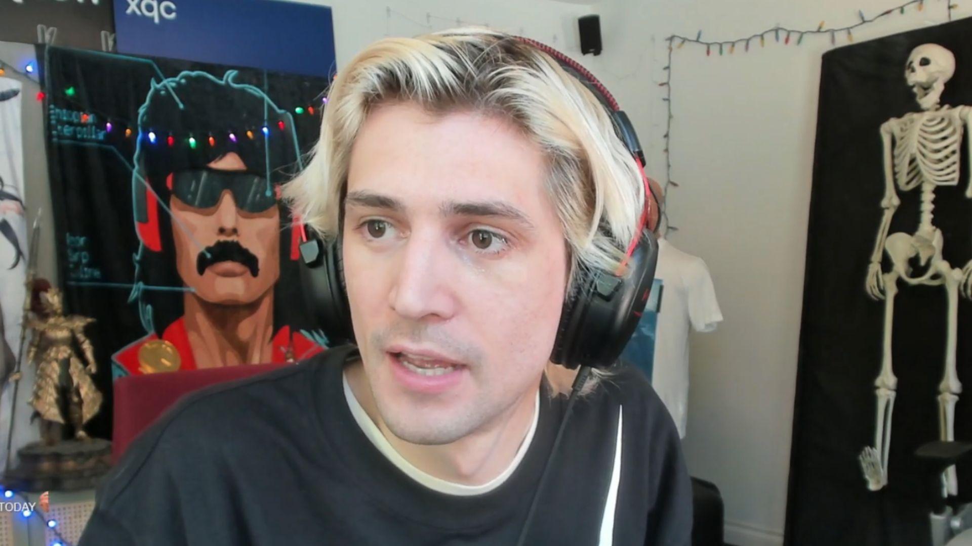xQc in black t shirt with white and red writing on talking to camera