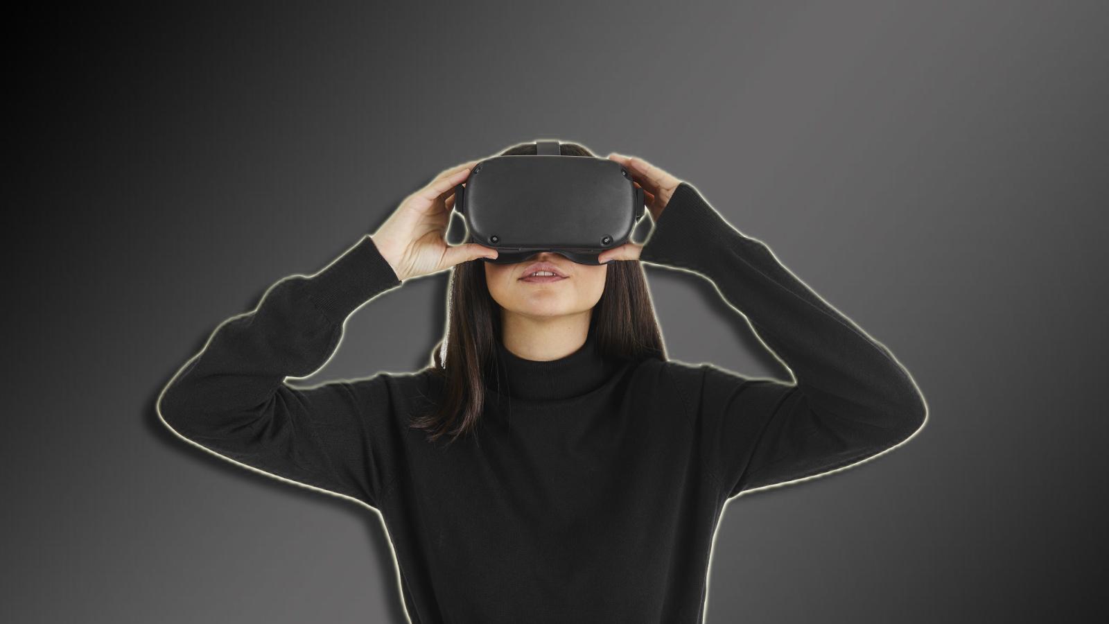 A woman wearing a VR headset on a dark bacground