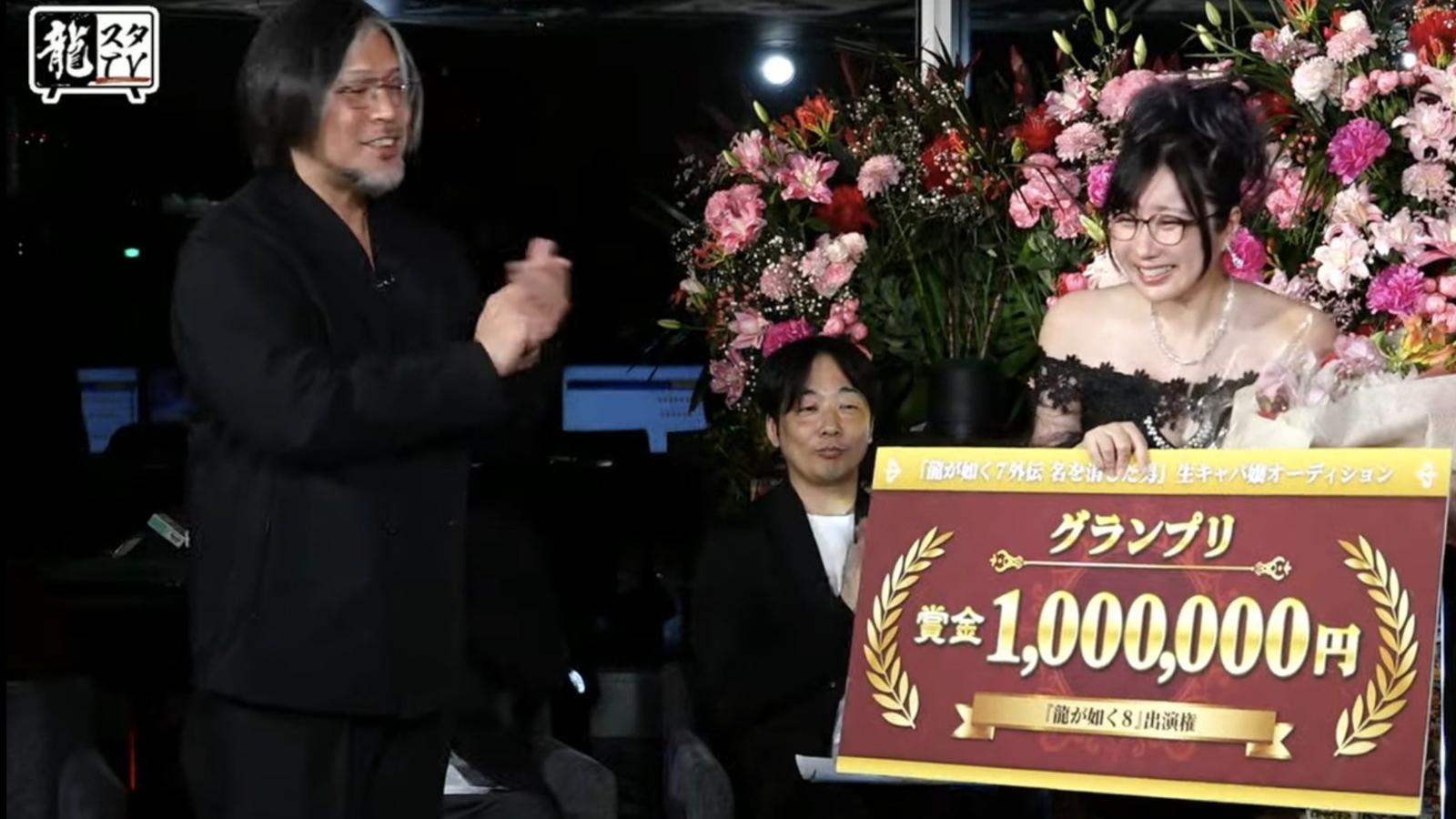 Winner of Sega's hostess contest, Kson, holding a 1 milion yen cheque