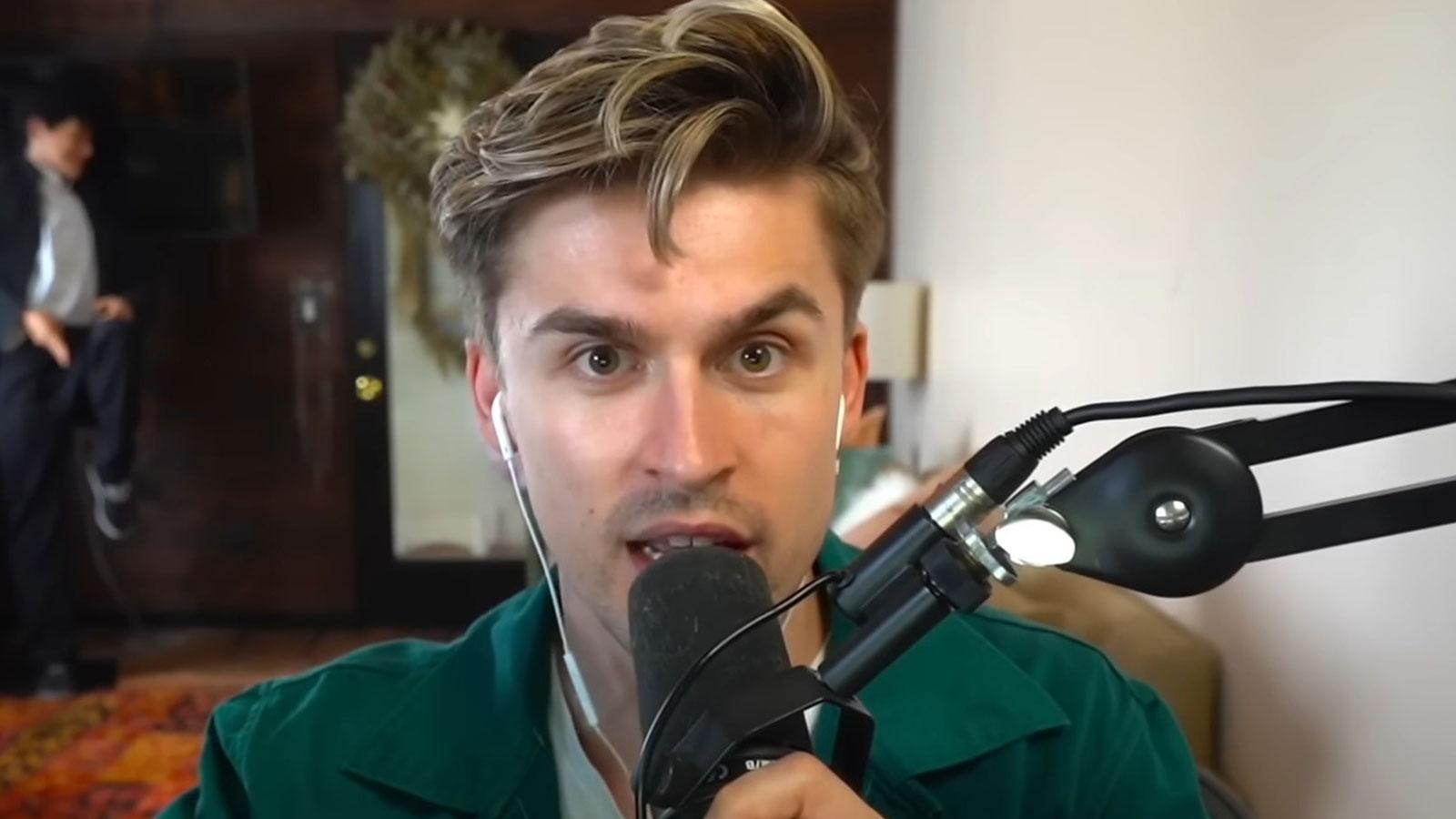 YouTube streamer Ludwig sat at his desk holding SHURE SM7B microphone