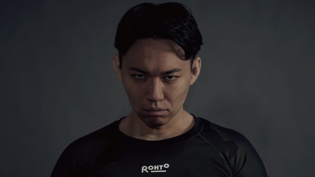 Tokido doing a murderface on a grey background