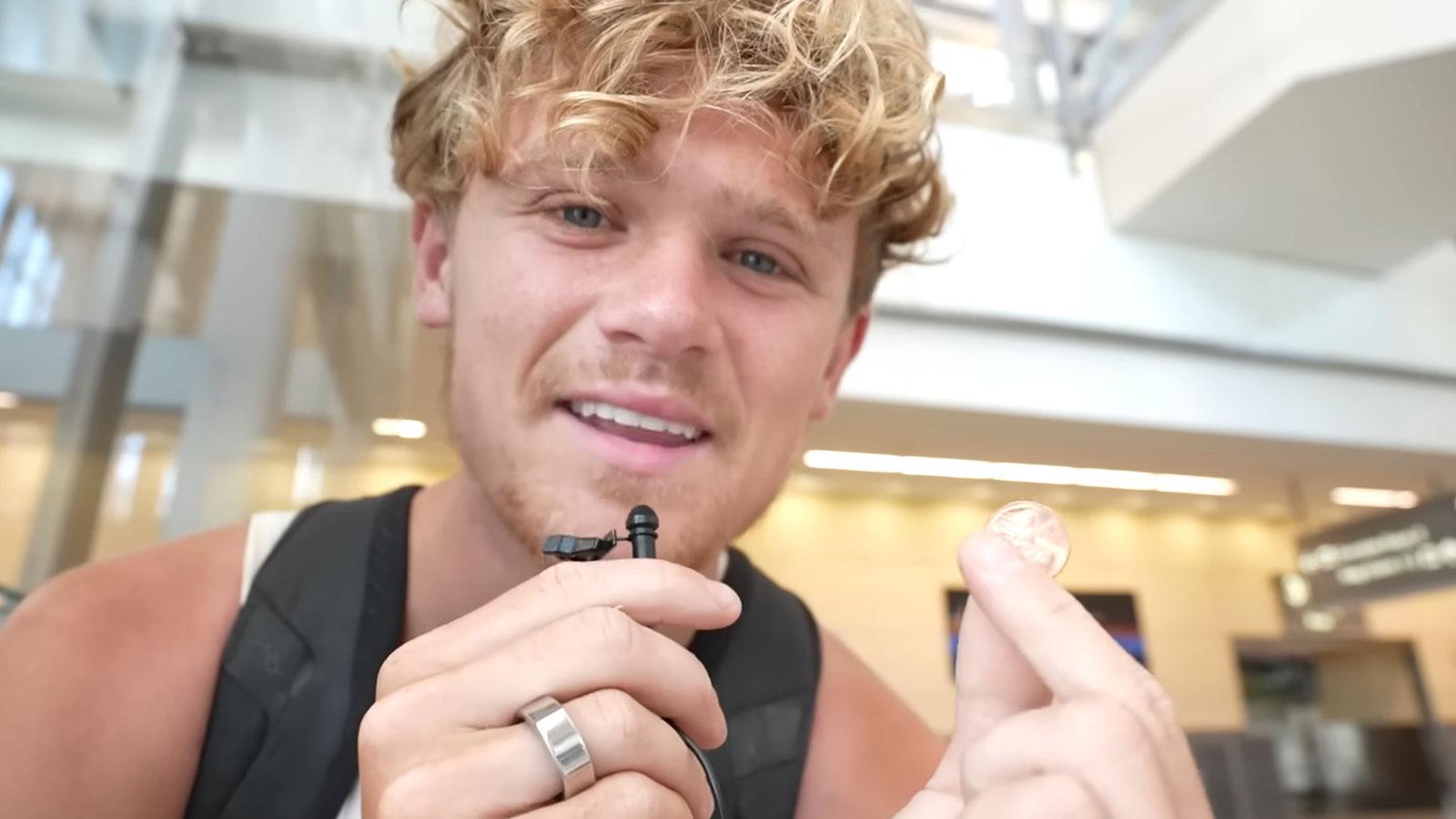 YouTuber Ryan Trahan holding a penny in an airport