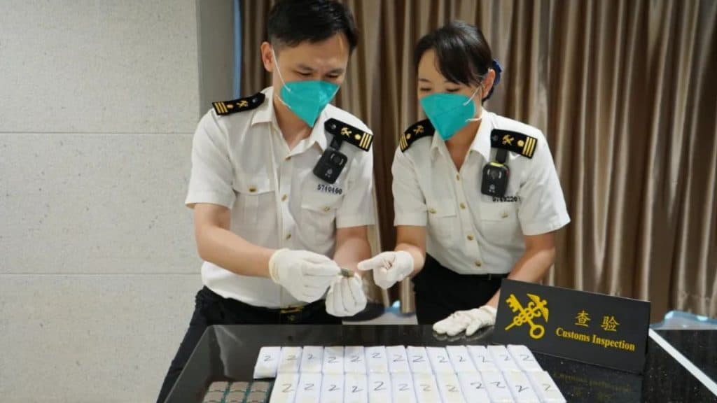 Men looking at smuggled CPUs on a table