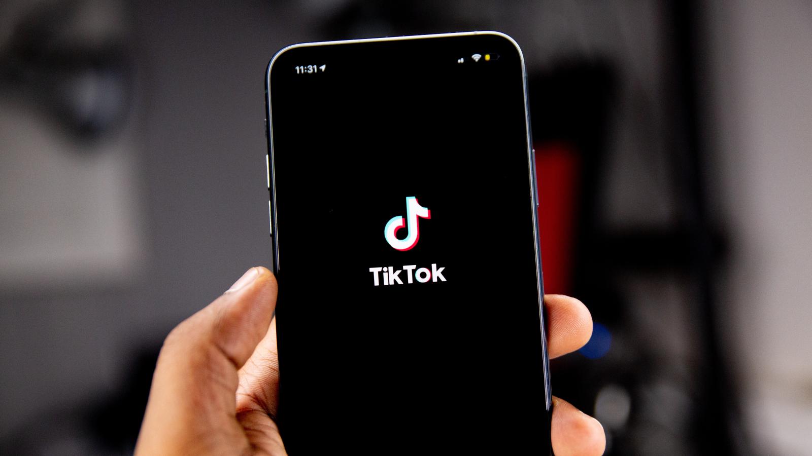 Person holding a phone with the TikTok logo on it.