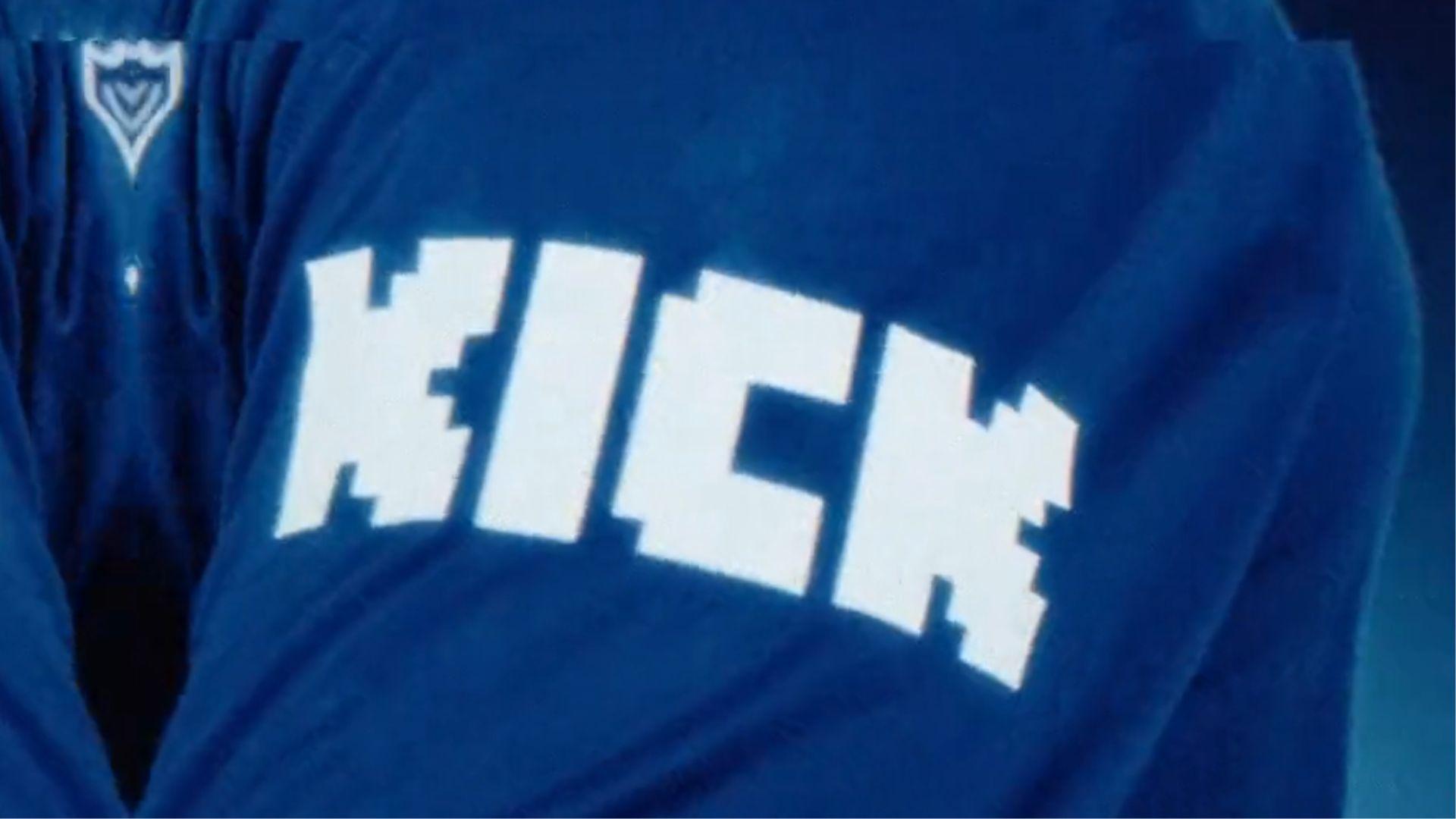 Kick logo on blue shirt pointed at camera