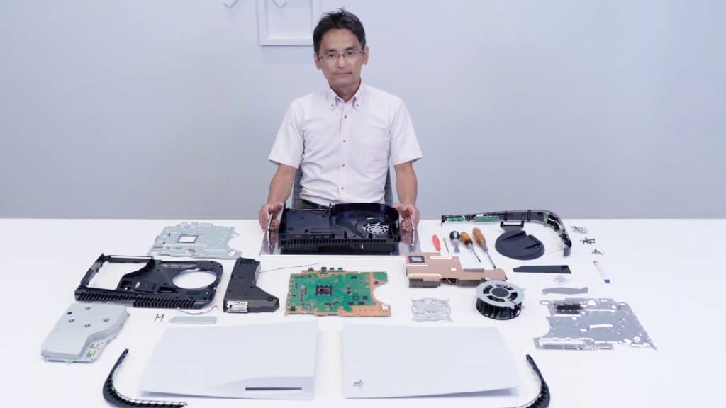 A PS5 disassembled with a man sitting by it