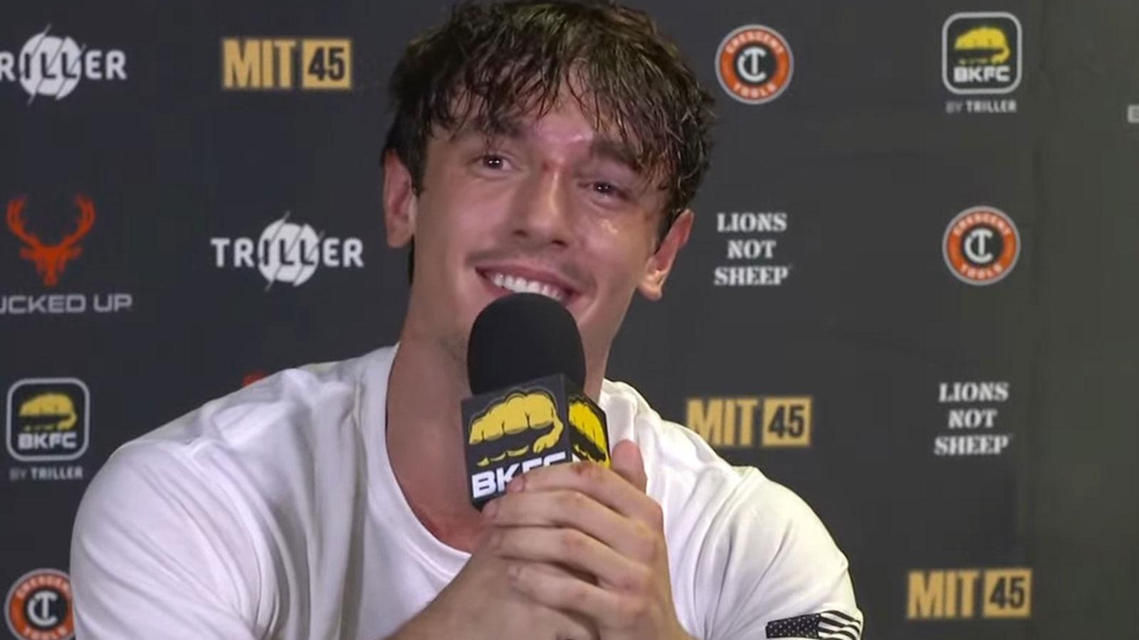 Bryce Hall holding a microphone at BKFC post-fight press conference