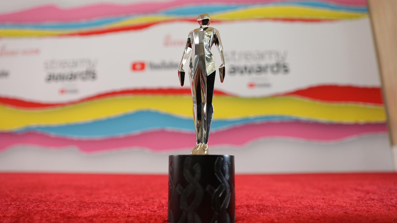 A photo of a Streamy Award trophy on the red carpet.