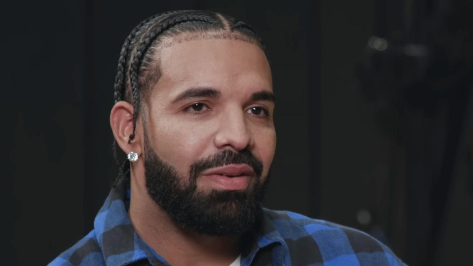 Drake in blue and black shirt talking to camera