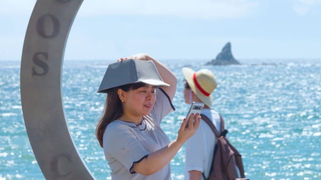 Woman wearing keycap hat by the sea