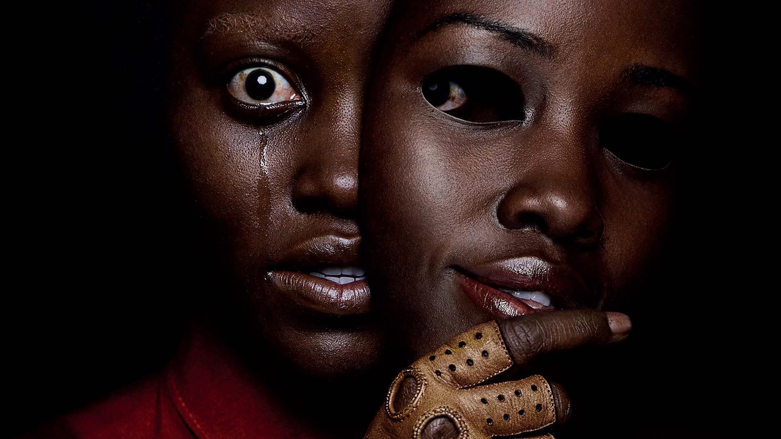 Lupita Nyong'o holding a mask of herself in Us.
