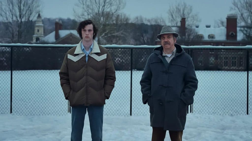 Dominic Sessa and Paul Giamatti standing in the snow in The Holdovers.