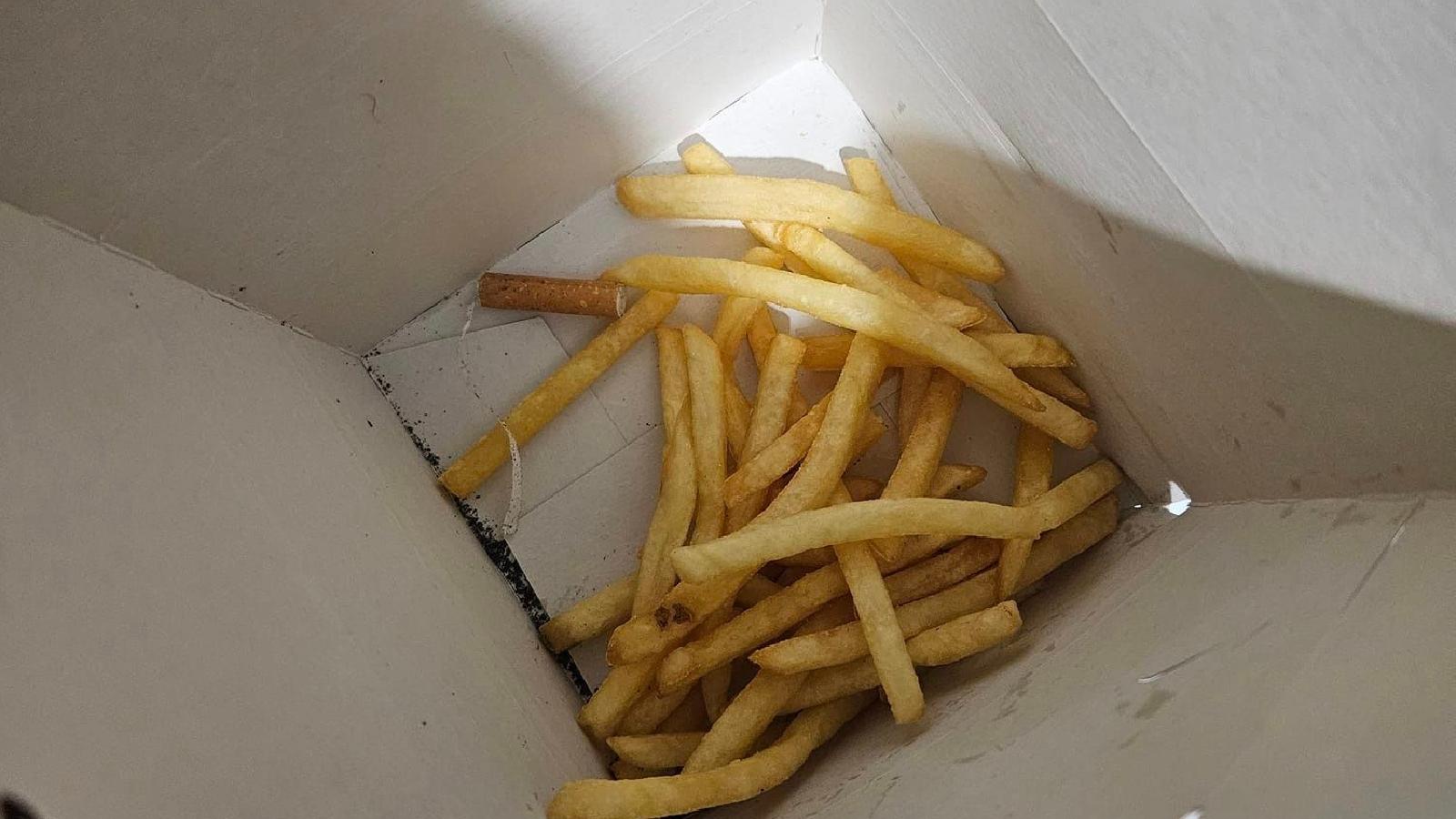 Image shows a cigarette butt found in a McDonald's Happy Meal
