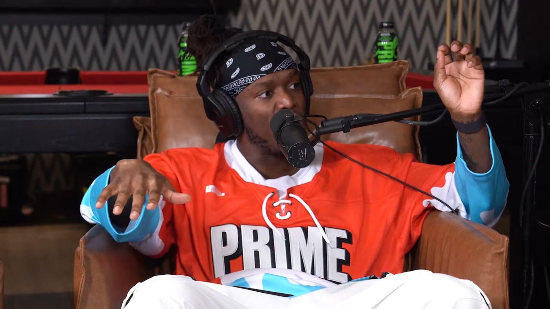 KSI in red and blue prime hockey jersey talking into microphone