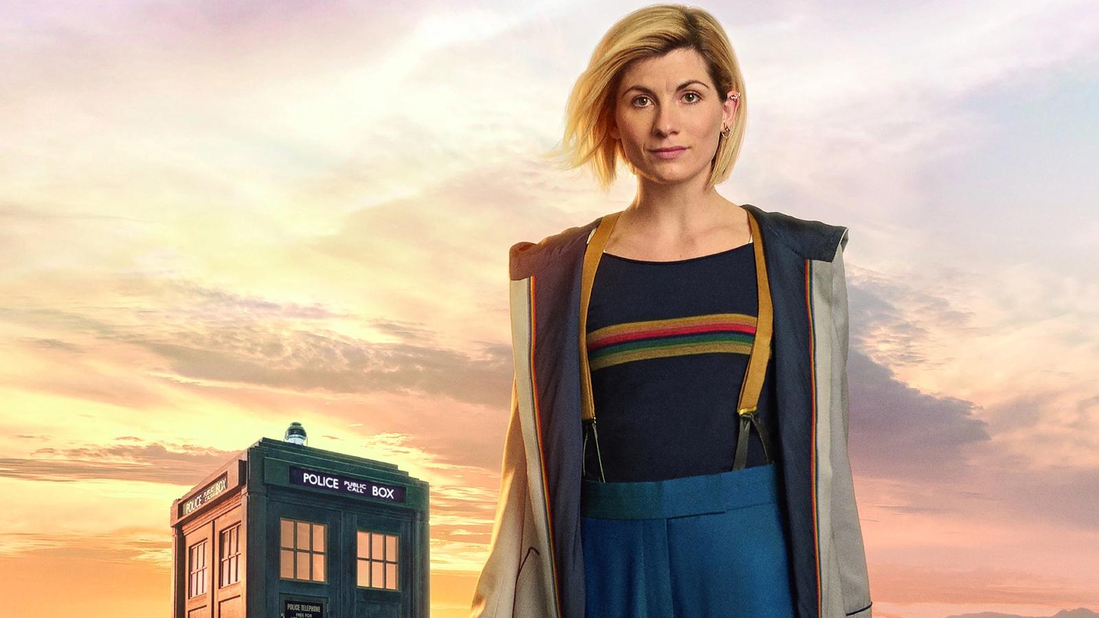 Jodie Whittaker as the Thirteenth Doctor standing in front of the TARDIS in a Doctor Who promotional still.