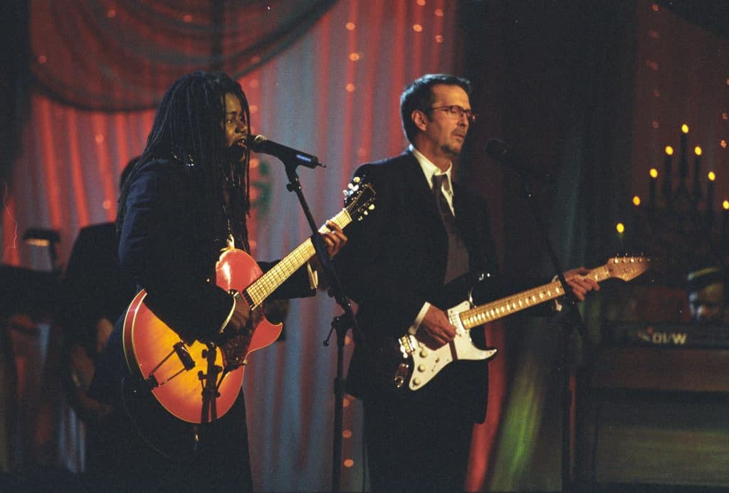 Tracy Chapman performing onstage with a guitar.