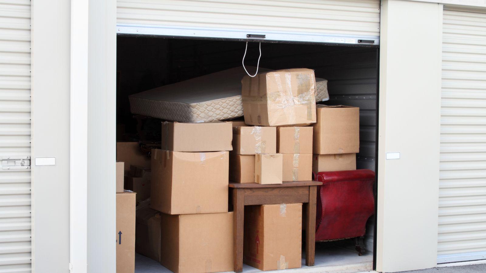 An open storage unit with cardboard boxes stacked inside
