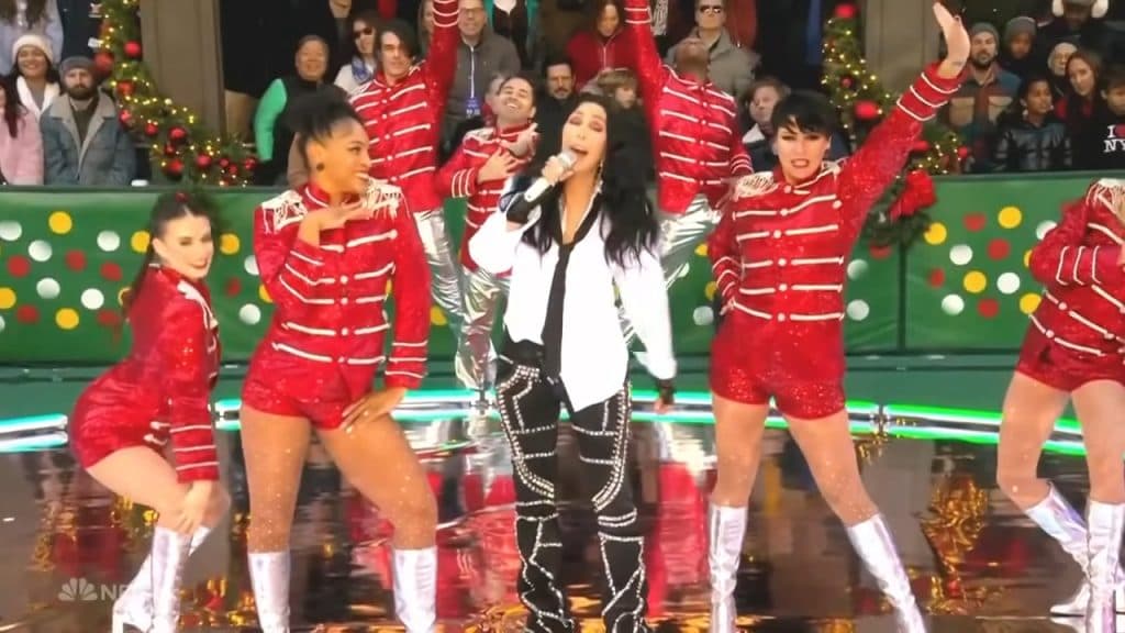 Cher in a jacket performing outside at a concert