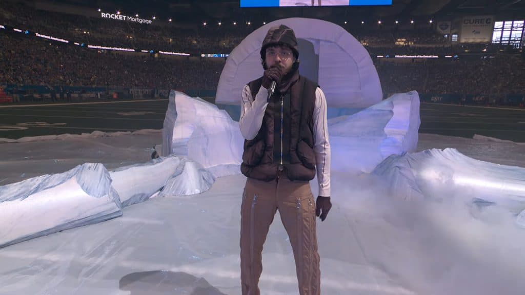 Jack Harlow in snow gear performing in front of a fake igloo