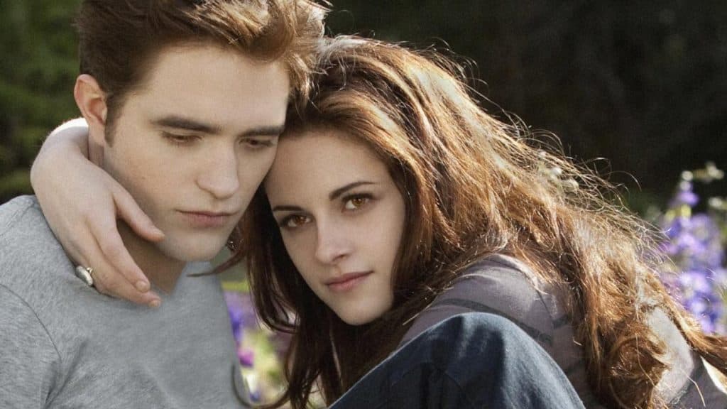 Kristen Stewart with her arm around Robert Pattinson in Twilight.